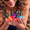 Vrouw die een hoop nagellak flesjes in de handen heeft