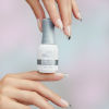 Vrouw die met twee handen een flesje Orly GelFX Builder in a Bottle presenteert